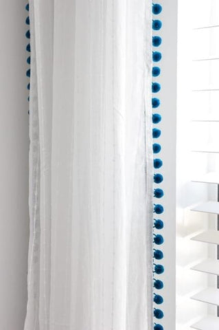 Sheer white curtains with blue detailing at edges