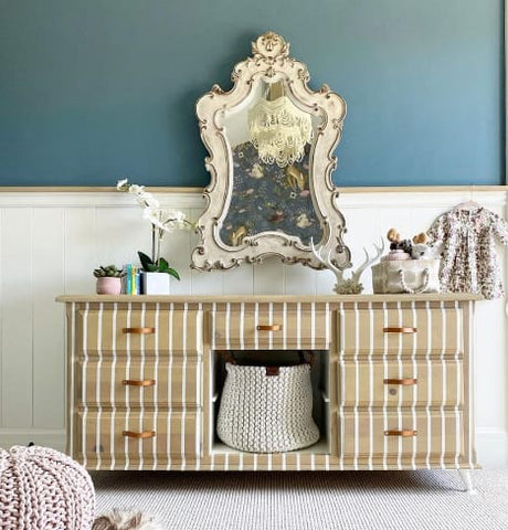 Changing station in front of a shiplap nursery wall