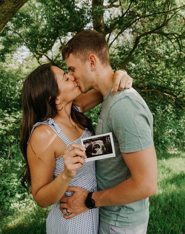 DIY pregnancy announcement photo of a couple holding an ultrasound photo
