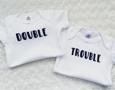 Baby onesies that say "double" and "trouble"