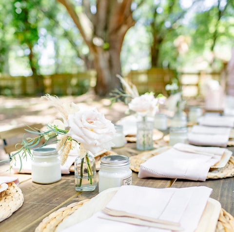 Outdoor table set with white flowers and linens for a summer baby shower