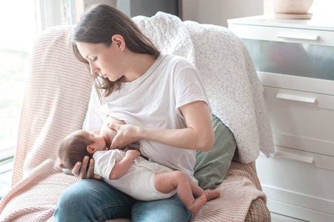A mother breastfeeds her newborn baby