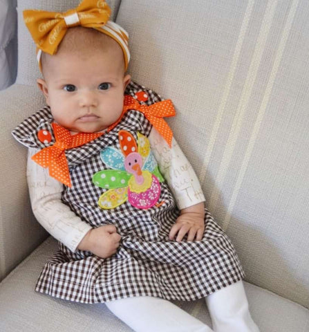 Cute baby wearing a Thanksgiving outfit
