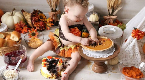 First Thanksgiving baby photoshoot where a baby is eating pumpkin pie