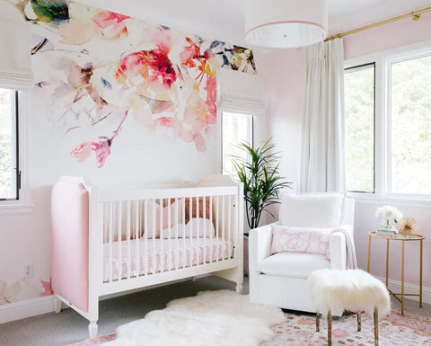 A contemporary floral nursery featuring a bold flower wall decal behind a tufted crib