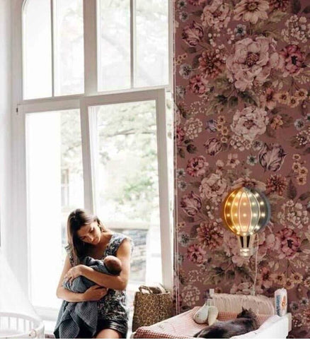 A floral nursery that features dark-colored flower wallpaper