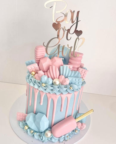 Elaborately decorated pink and blue gender reveal cake