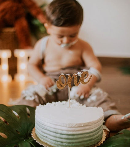 Baby digging into an ombré green smash cake