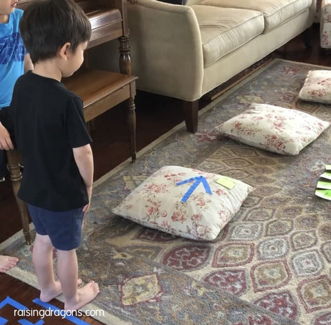 Toddler gets ready to complete an indoor obstacle course made from pillows