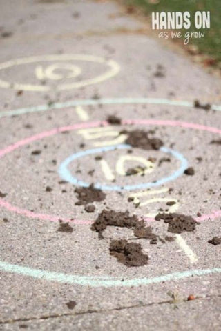 Chalk target on sidewalk splattered with dirt.