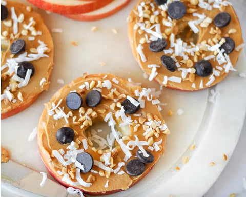 Apple rings topped with peanut butter, shredded coconut, and chocolate chips