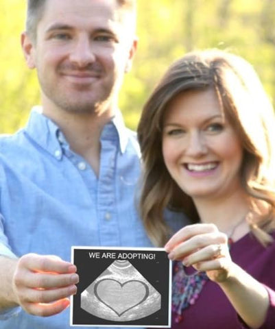 Couple holds ultrasound-style photo with heart in the middle