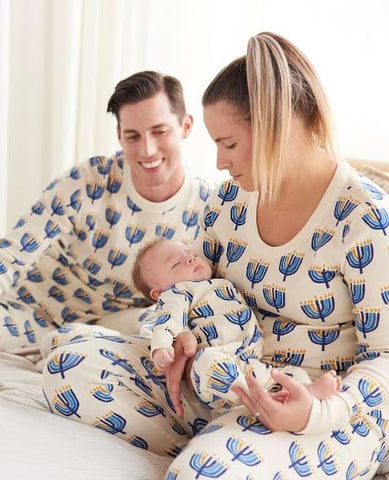 Family celebrating baby's first holiday by wearing matching Hanukkah PJs