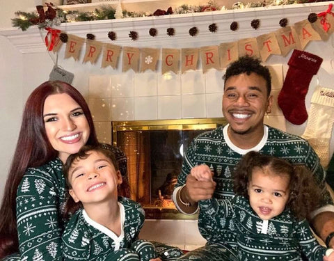 A family poses by a fireplace for a holiday photo