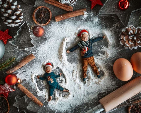 Two children pose as gingerbread cookies for a holiday card photo