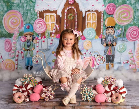 A little girl poses with nutcracker scenery for a holiday photo