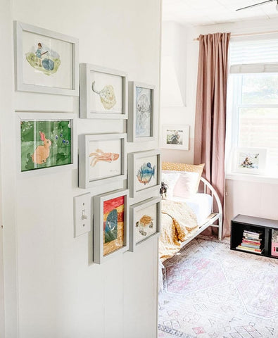 Gallery wall with framed pieces of child's artwork