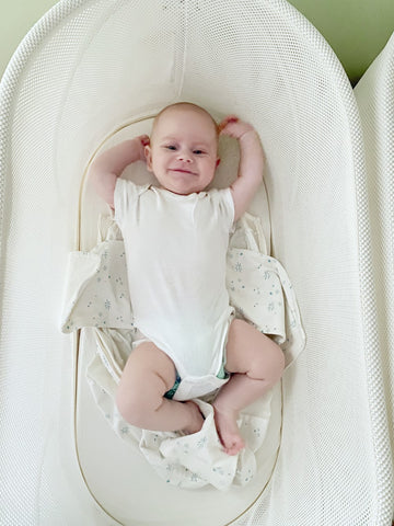 Baby doing a SNOO stretch in SNOO bassinet