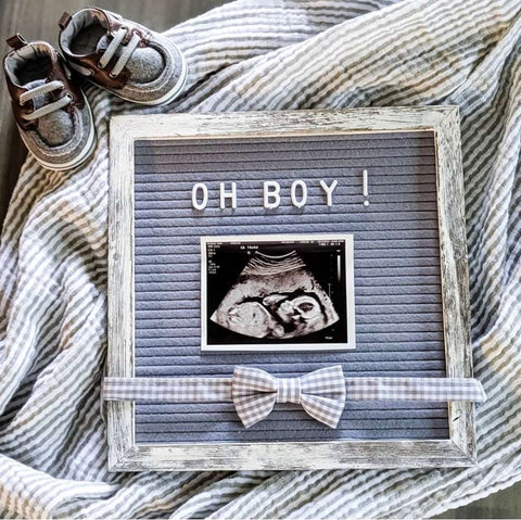A letterboard boy pregnancy announcement accessorized with a bow tie