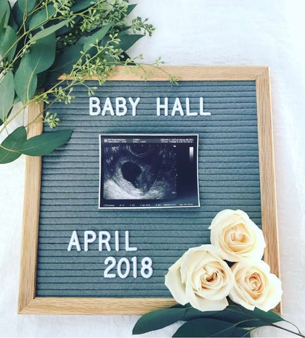 A simple letterboard pregnancy announcement with flowers