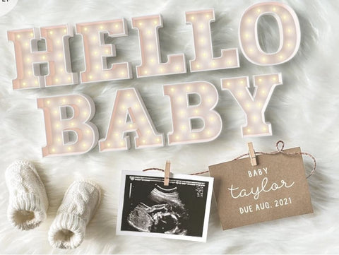 Marquee-style lights spell out "hello baby" in a pregnancy announcement template