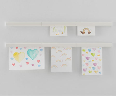 Kids art displayed on the wall with magnetic strips