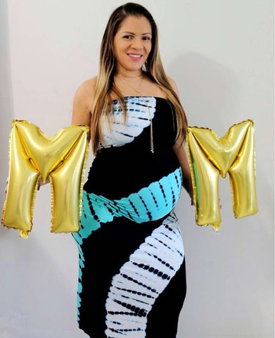 Mother's Day pregnancy announcement featuring a pregnant mom holding "M" balloons on either side of her bump to spell "MOM"