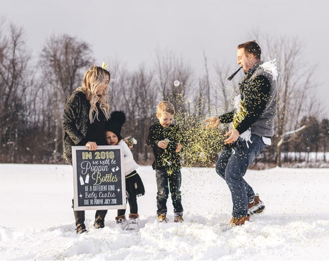 Snowy outdoor photo shoot for a New Year's pregnancy announcement