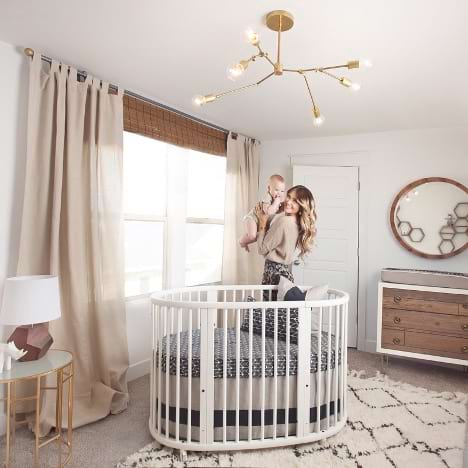A nursery layout with the crib in the center of the room
