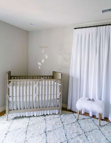 A nursery layout with a crib in the corner