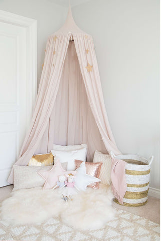 A pink canopy in the corner of a baby's room