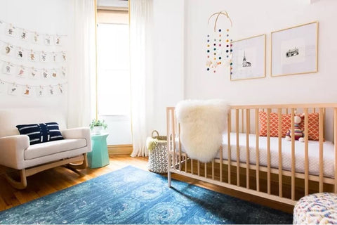 A bright blue nursery rug in a baby's room