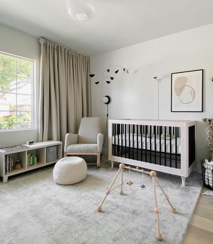 A baby room with a gray nursery rug