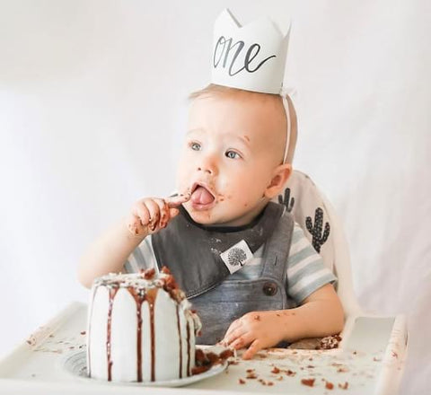 Baby eating Petit Prince-themed smash cake.