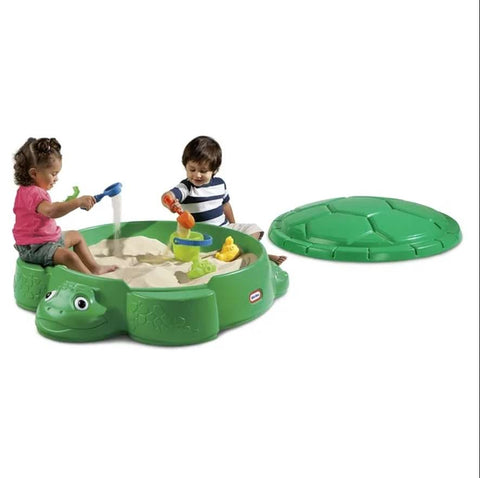 Two toddlers play in a sandbox during a playdate