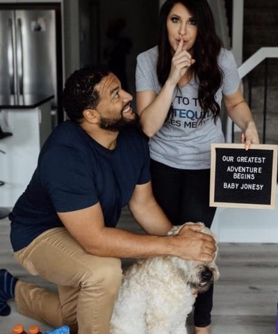 Couple with dog and pregnancy announcement letterboard