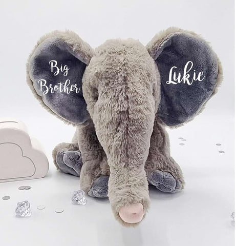 A stuffed animal elephant with the words "Big brother Lukie" embroidered on its ears to announce a pregnancy