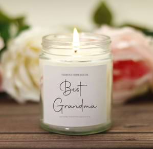 A pregnancy announcement candle that says "Best Grandma"