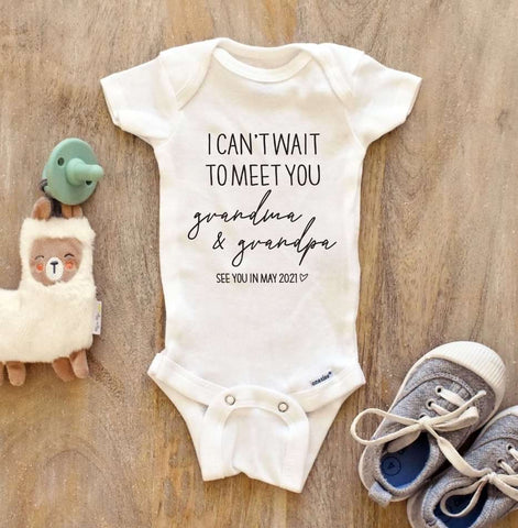 A baby onesie that says "I can't wait to meet you grandma and grandpa"