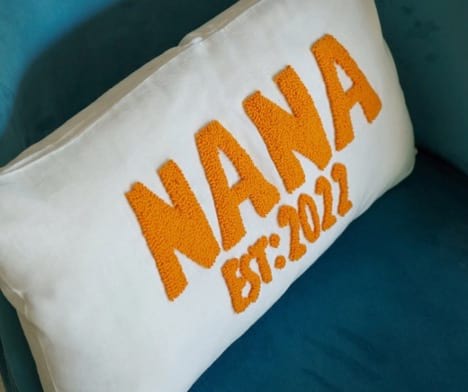 Throw pillow that says NANA EST: 2022 used to announce a pregnancy