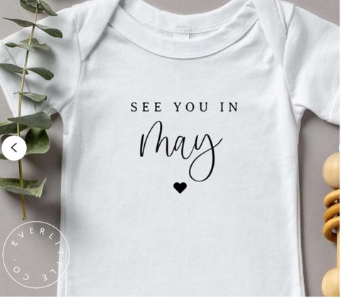 Pregnancy announcement onesie that says "See you in May"