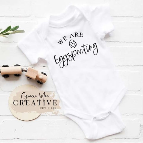 Easter pregnancy announcement onesie that says "we're eggs-pecting"