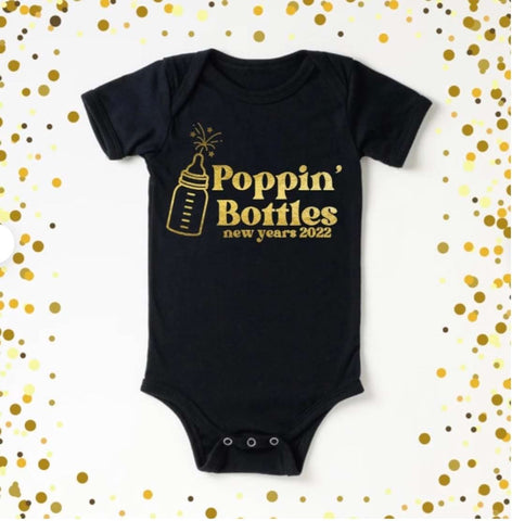 New Year's pregnancy announcement onesie that says "poppin bottles" with the image of a bottle