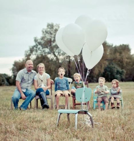 Family poses with empty chair for adoption announcement