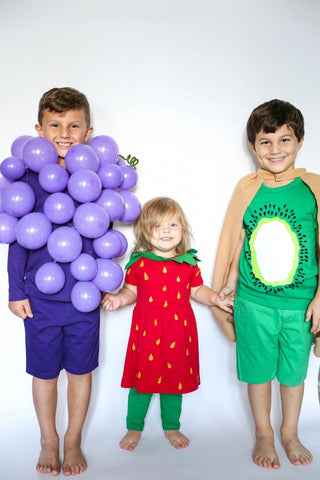 Fruit Halloween costume: siblings dressed as grapes, a strawberry, and a kiwi