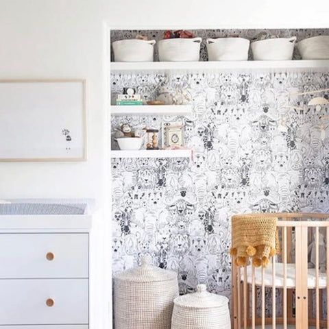 Closet that has been transformed into a nursery nook with floating shelves and a mini crib.