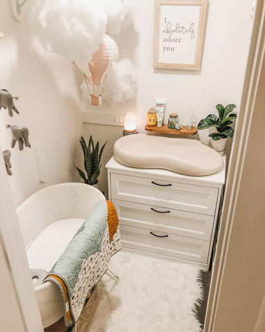 Walk-in closet that has been turned into a nursery with a bassinet and changing table.