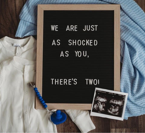 A letterboard twin pregnancy announcement that says "We're just as shocked as you are"