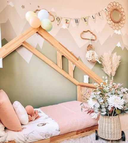 Toddler floor bed in a pink and green toddler room.