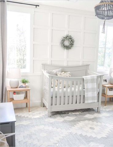 All-white baby nursery with light gray crib and rug